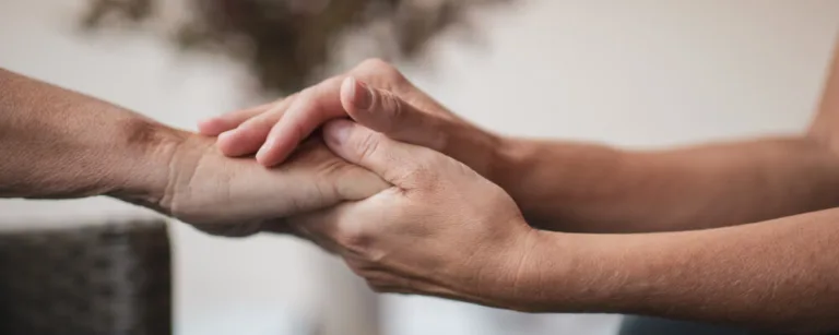 two people holding hands, comforting each other