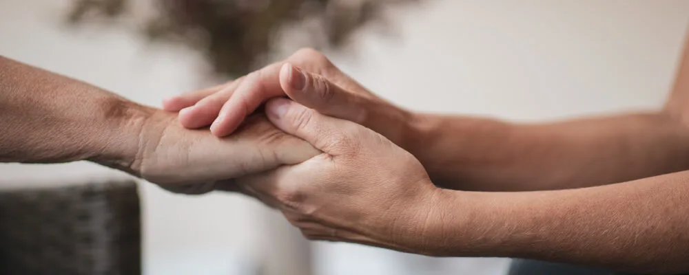 two people holding hands, comforting each other