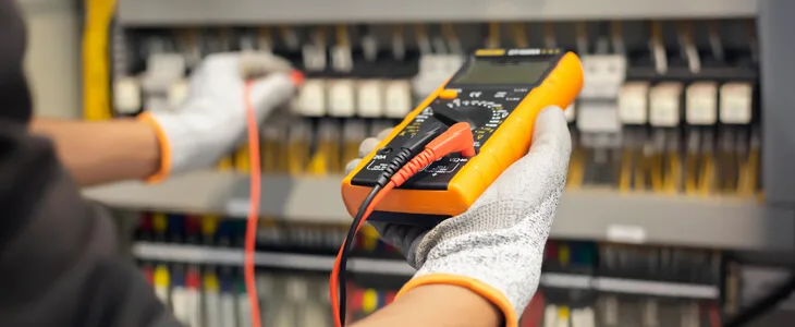 Electrician testing the charge and power of a fuse box