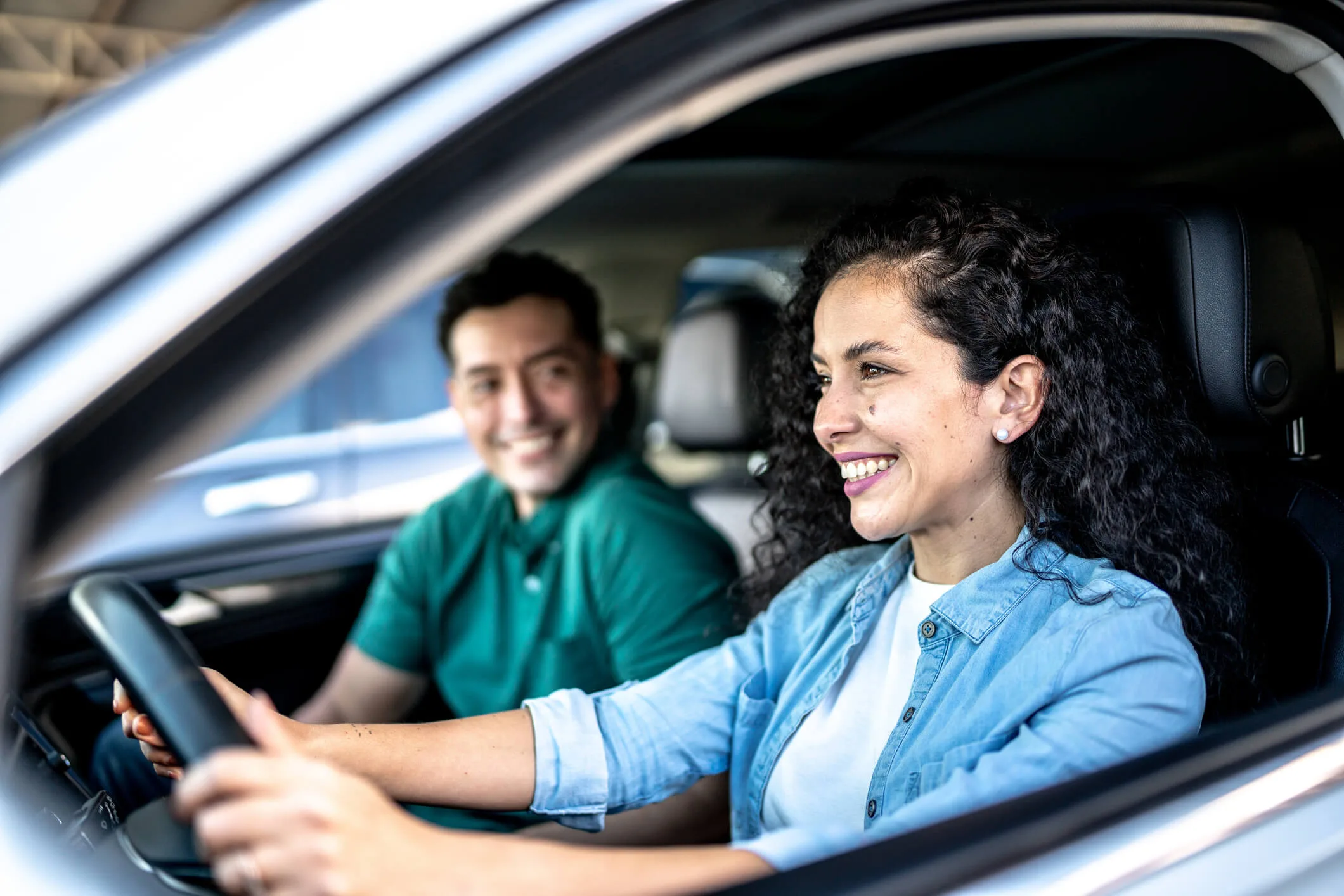 Mid adult woman driving a car with her husband in city
